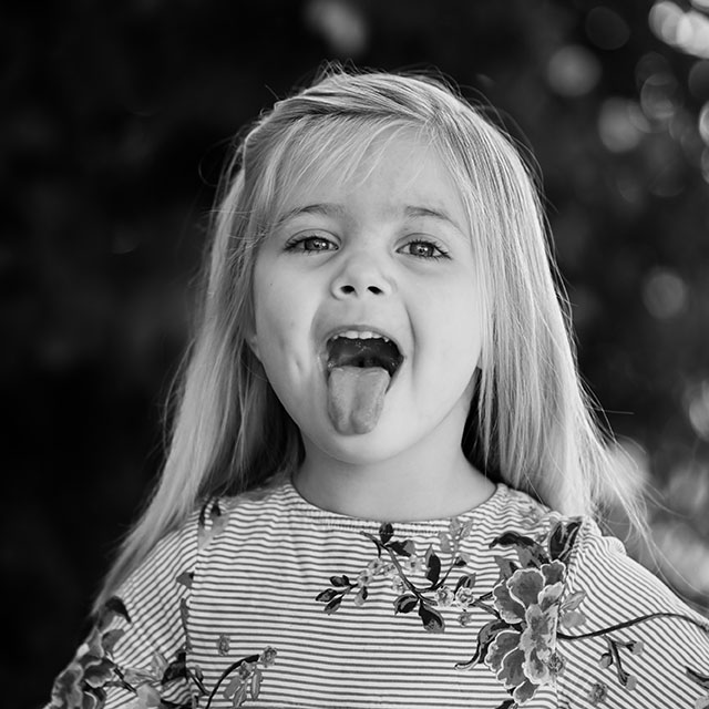 a kid posing on the camera in black and white